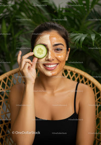 Young Woman with Facial Mask and Cucumber in a Wellness Setting