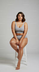 Confident Plus Size Woman Sitting on Stool in Casual Gray Outfit