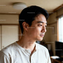 Thoughtful young man looking out bright window