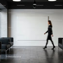 Businesswoman walking in modern office lobby with blank canvas