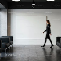 Businesswoman walking in modern office lobby with blank canvas