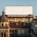 Two men standing near large blank billboard on rooftop