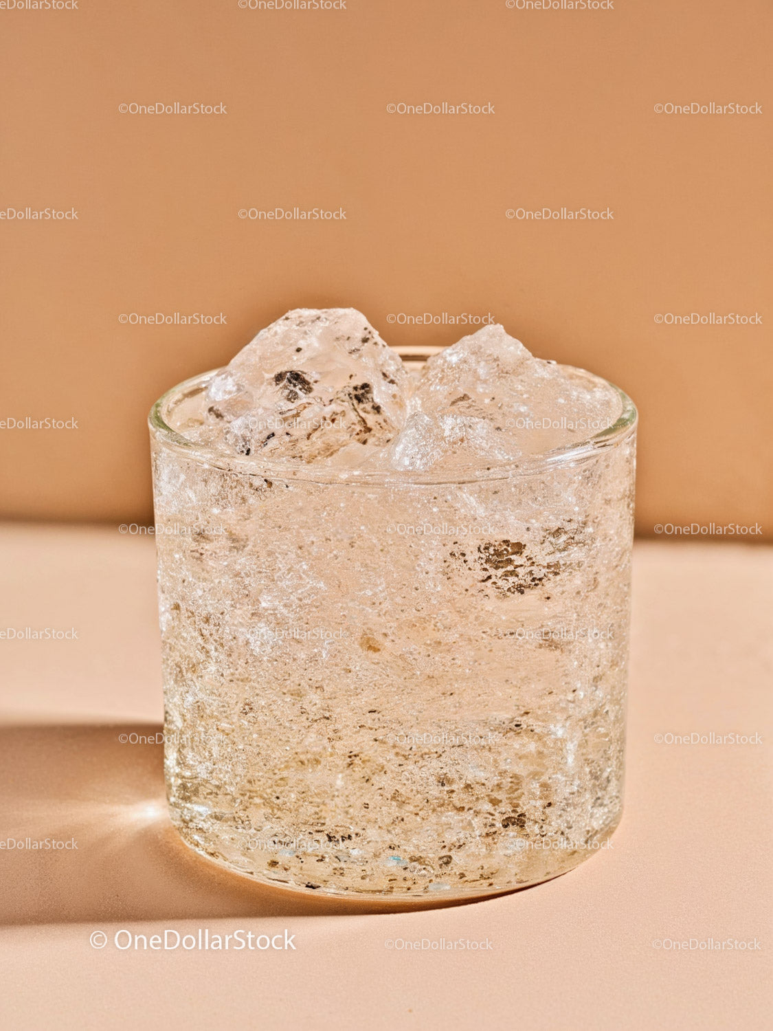 Close up of glass filled with sparkling water and ice cubes
