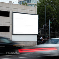 Blank urban billboard above busy city street at dusk