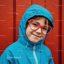 Smiling child in blue hoodie and red heart glasses