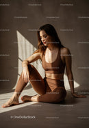 Calm woman relaxing in sunlight wearing brown activewear