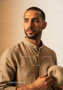 Portrait of a Confident Man in Beige Shirt Holding a Hat for Fashion