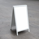 Blank white sandwich board on concrete outdoor surface