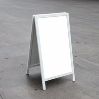 Blank white sandwich board on concrete outdoor surface