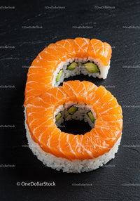Salmon Sushi Roll Shaped As Number Six On Black Slate