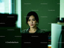 Thoughtful young woman working late in dim office