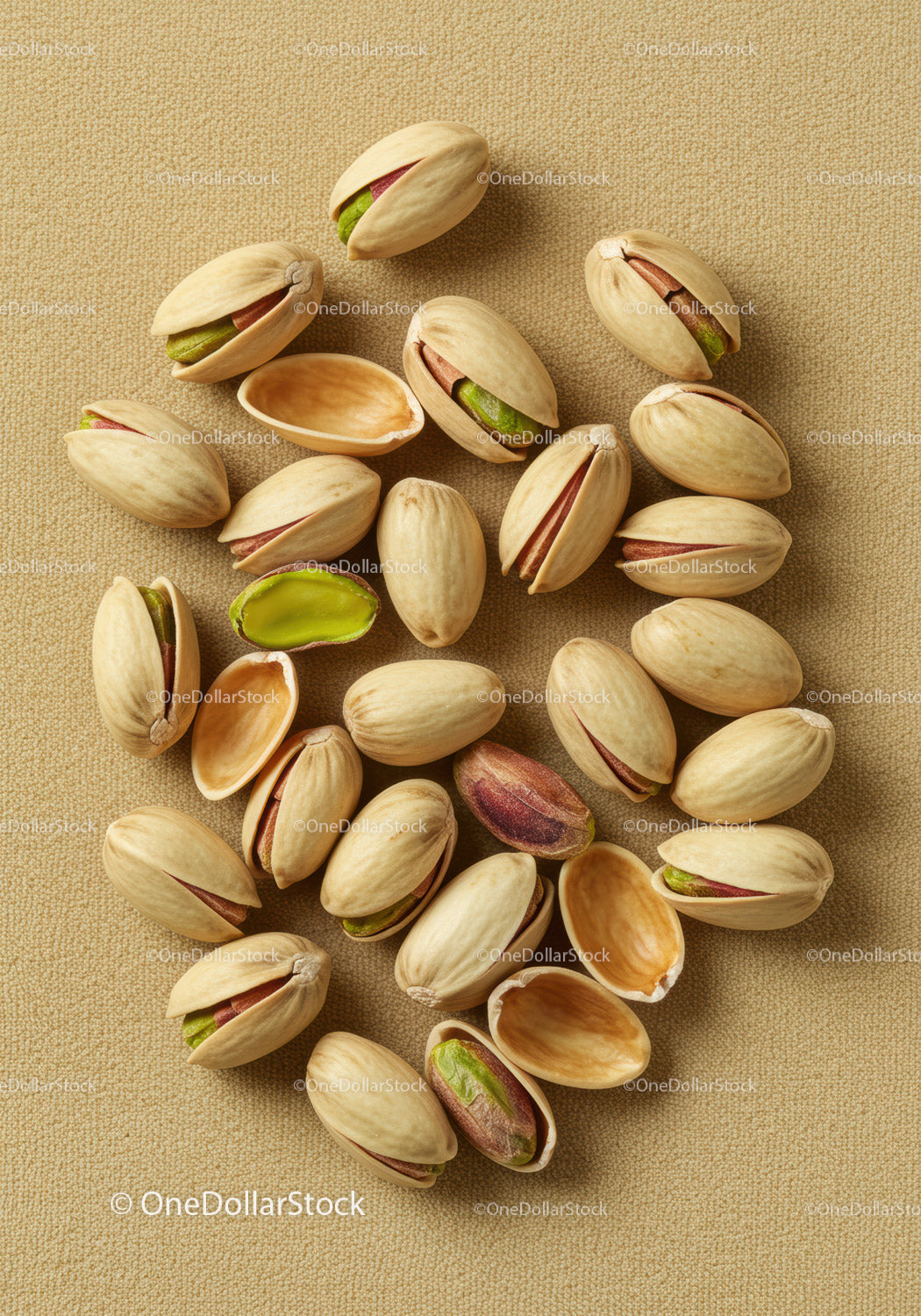 Close up of pistachio nuts on textured fabric background