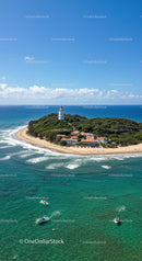 Scenic Coastal Island with Lighthouse and Boats Under Blue Sky