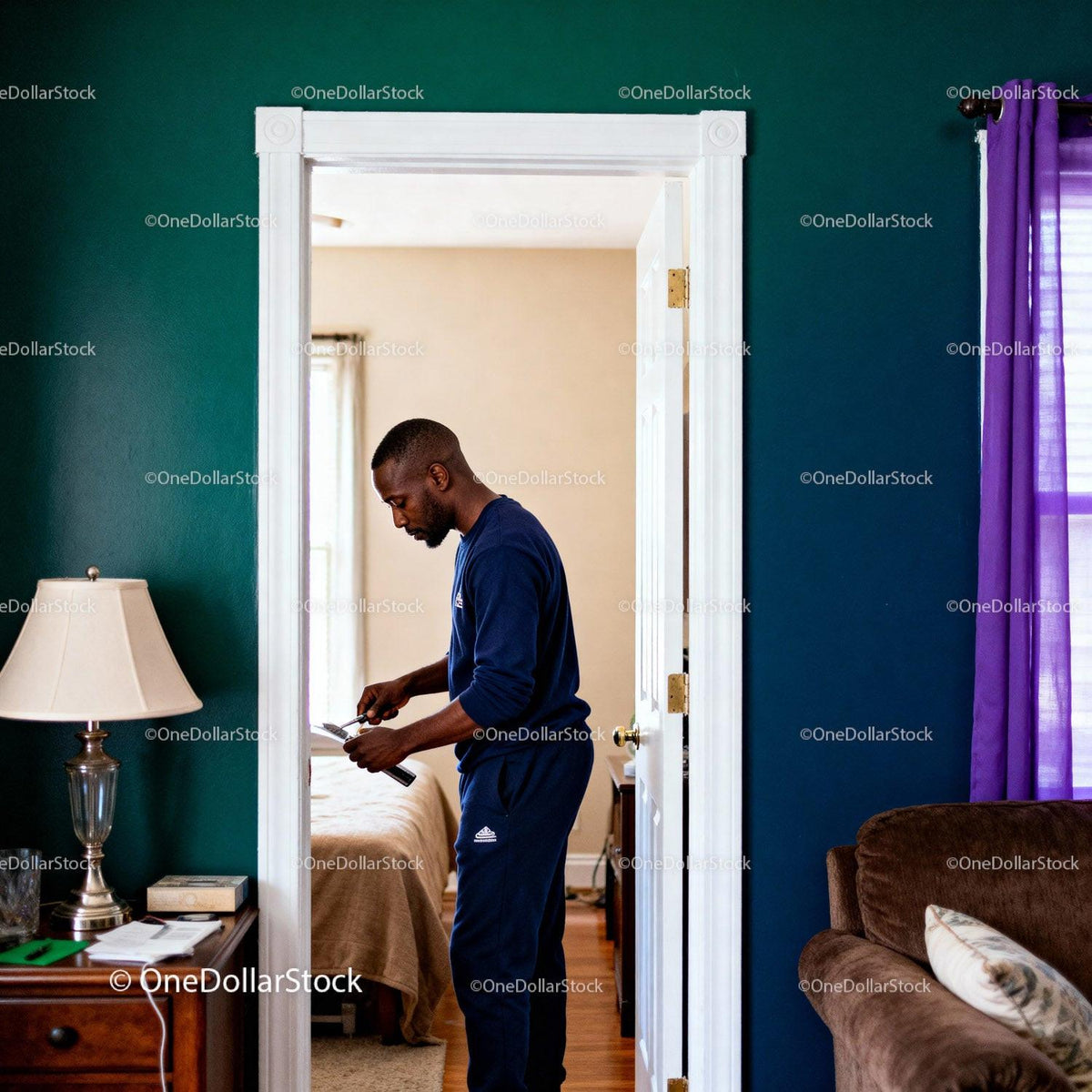Man focused on smartphone in cozy home interior
