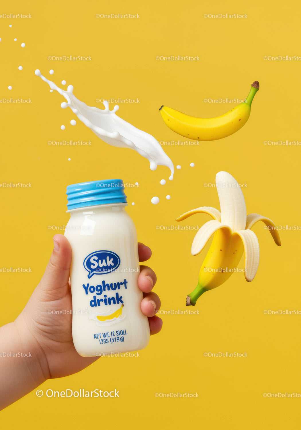 Hand holding banana flavored yoghurt drink with splash
