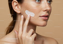 Close-Up of Woman Applying Skincare Cream to Flawless Skin