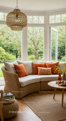 Cozy rattan sofa with orange cushions in sunlit room