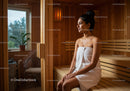 Relaxing Woman Sitting in Wooden Sauna Room with Towel