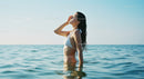 Young Woman Relaxing in Blue Ocean During Sunny Day