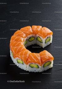 Fresh salmon and avocado sushi roll on dark slate