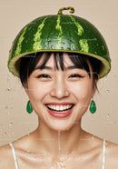 Smiling woman wearing watermelon helmet with water drops