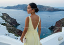 Elegant woman in yellow dress overlooking coastal cliffs