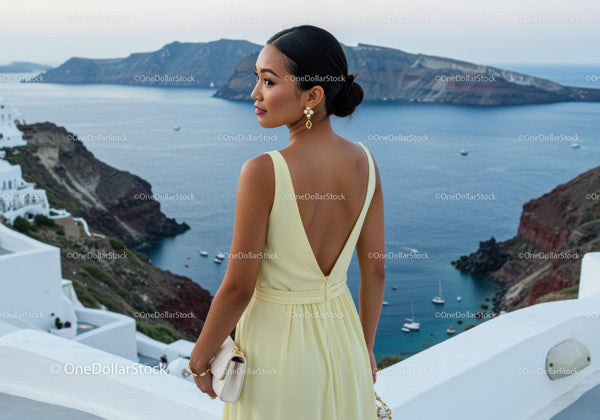 Elegant woman in yellow dress overlooking coastal cliffs