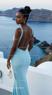Elegant woman in light blue dress overlooking serene sea view