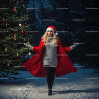 Young woman walking in snow wearing festive red coat