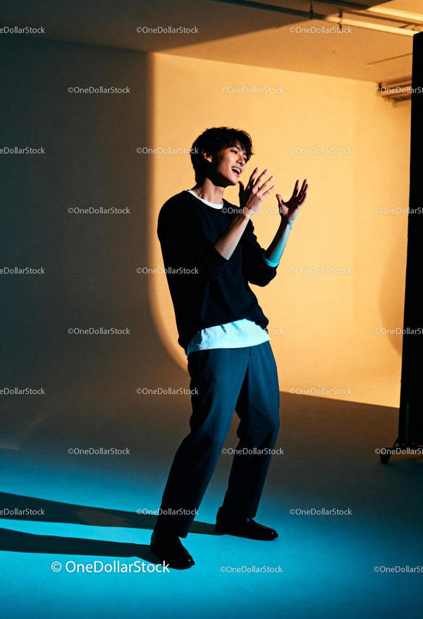 Young man expressing emotions in dramatic studio lighting