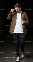 Young man adjusting glasses while walking confidently