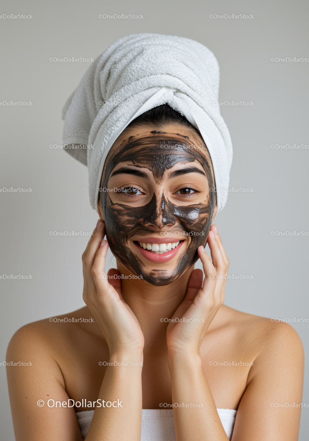 Młoda kobieta z maseczką na twarz i owinięta ręcznikiem w salonie spa