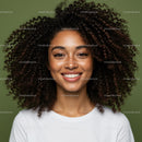 Portrait of a Smiling Woman with Curly Hair and Freckles on Green Background