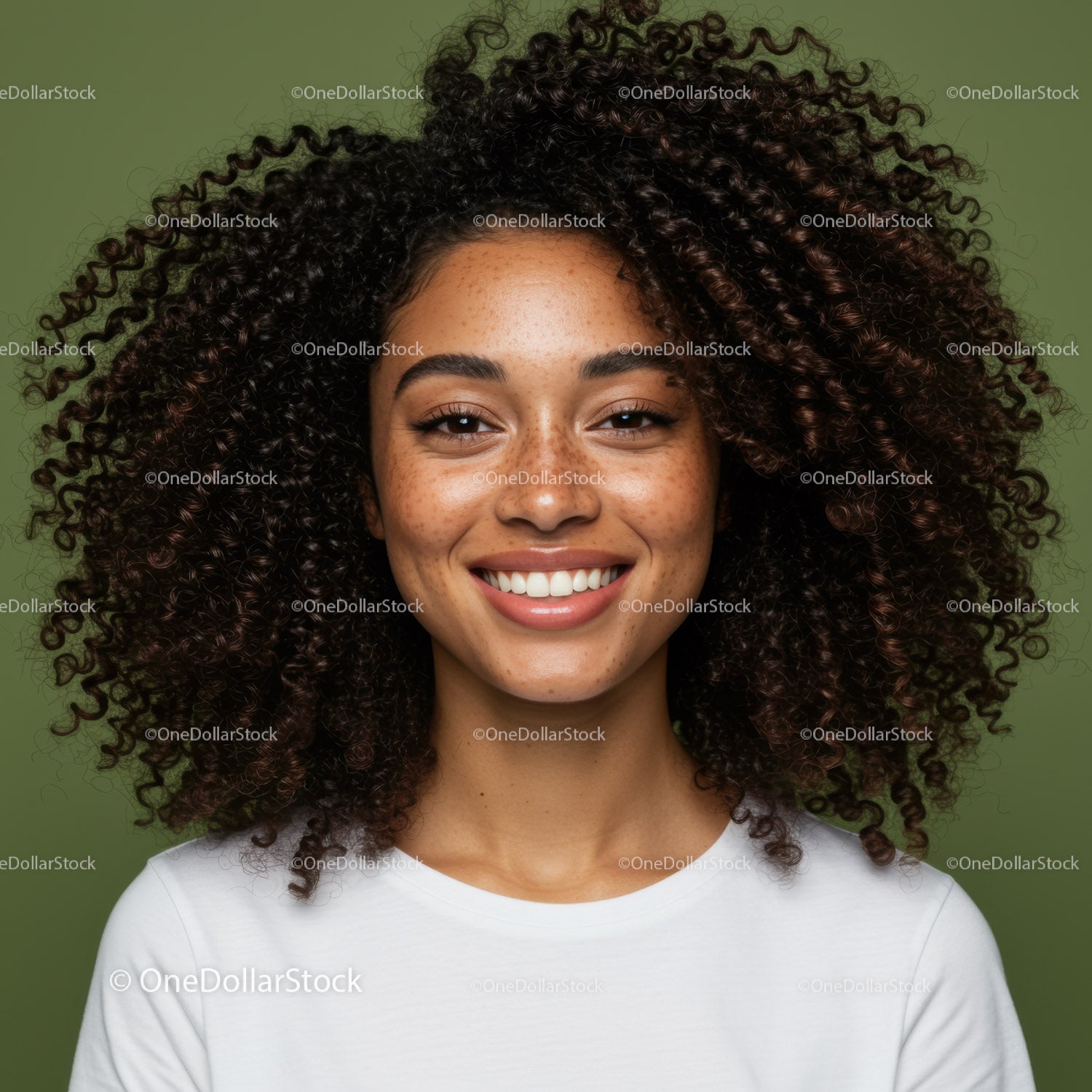Portrait of a Smiling Woman with Curly Hair and Freckles on Green Background