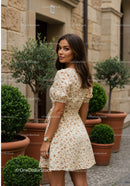 Charming Woman in Floral Dress Standing Outdoors on City Street