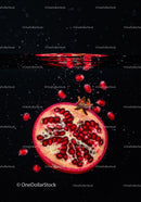 Fresh pomegranate halves with seeds falling underwater