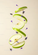 Fresh green apple slices with delicate purple flowers