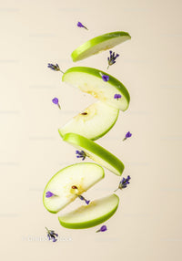 Fresh green apple slices with delicate purple flowers