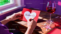 Writing a heartfelt Valentine's card by the window