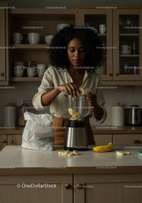Young woman preparing banana smoothie in modern kitchen