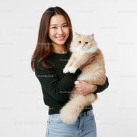 Happy woman holding fluffy cream cat in bright studio