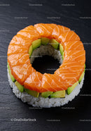 Ring-shaped sushi with salmon and avocado on black slate