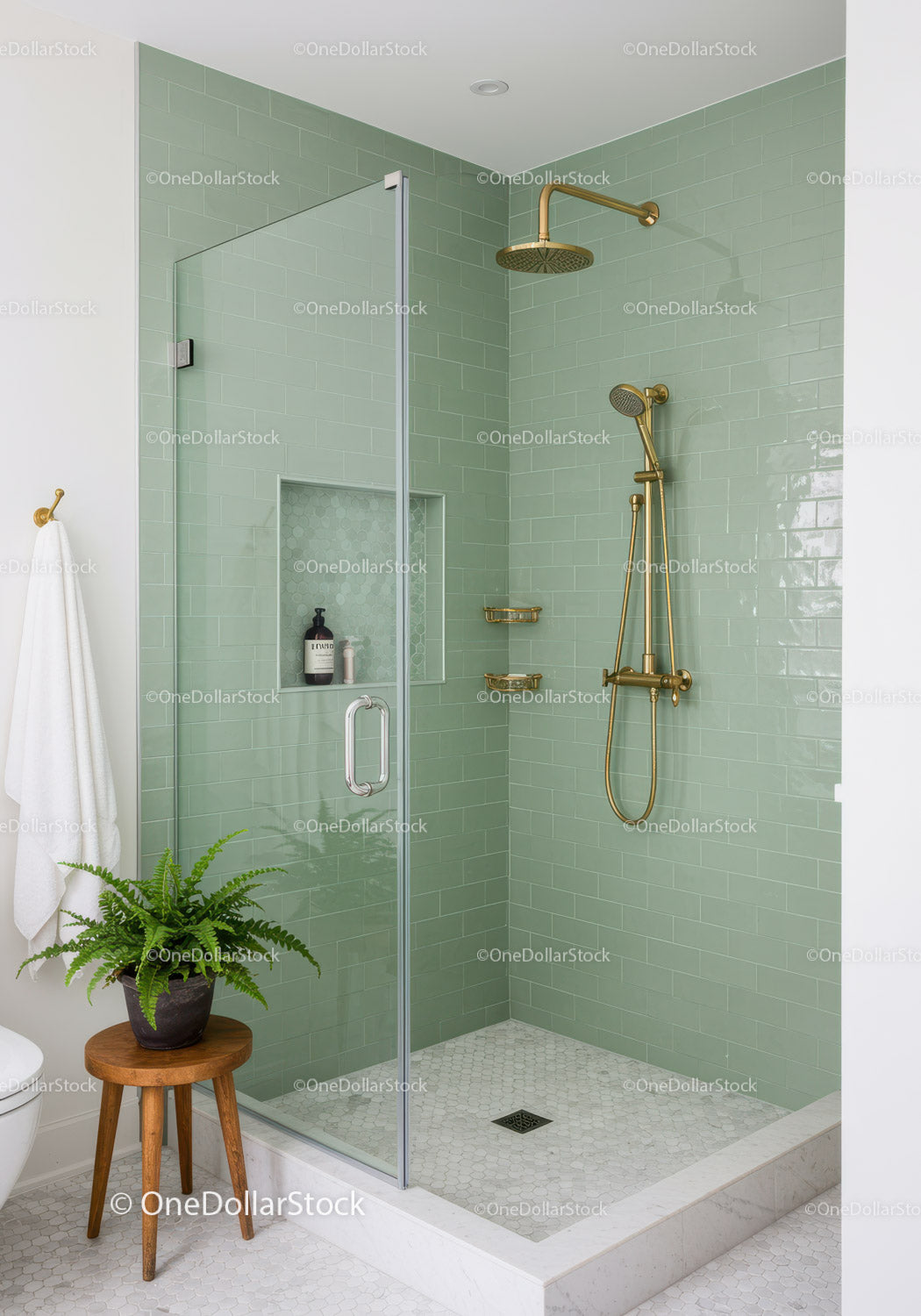 Modern bathroom with green tiled shower and gold fixtures