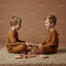 Two young boys playing with wooden blocks indoors