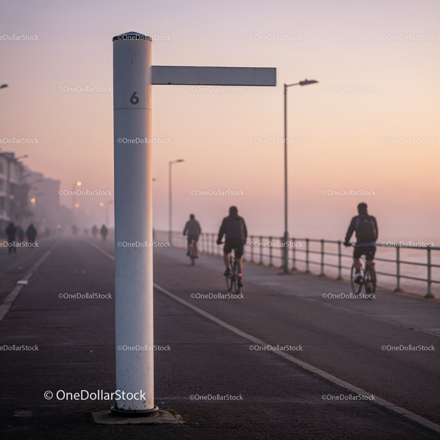 Early Morning Cyclists on Coastal Promenade