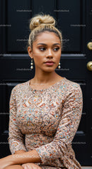 Thoughtful woman with floral dress sitting by dark door