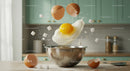 Fresh egg cracking in kitchen bowl with flying sugar cubes