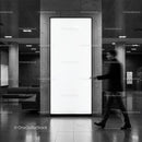 Man walking past large blank illuminated advertising panel