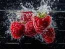 Red Raspberries in Water with Fruit Splash and Bubbles