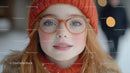 Young Woman Wearing Orange Knit Hat and Clear Glasses in Snowy Scene
